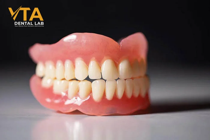 Full upper and lower porcelain dentures placed on a dental model for demonstration