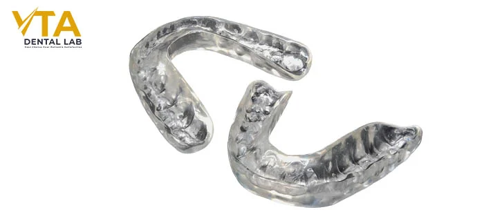 Close-up of a transparent hard-soft occlusal guard with a rigid outer layer and a soft inner lining
