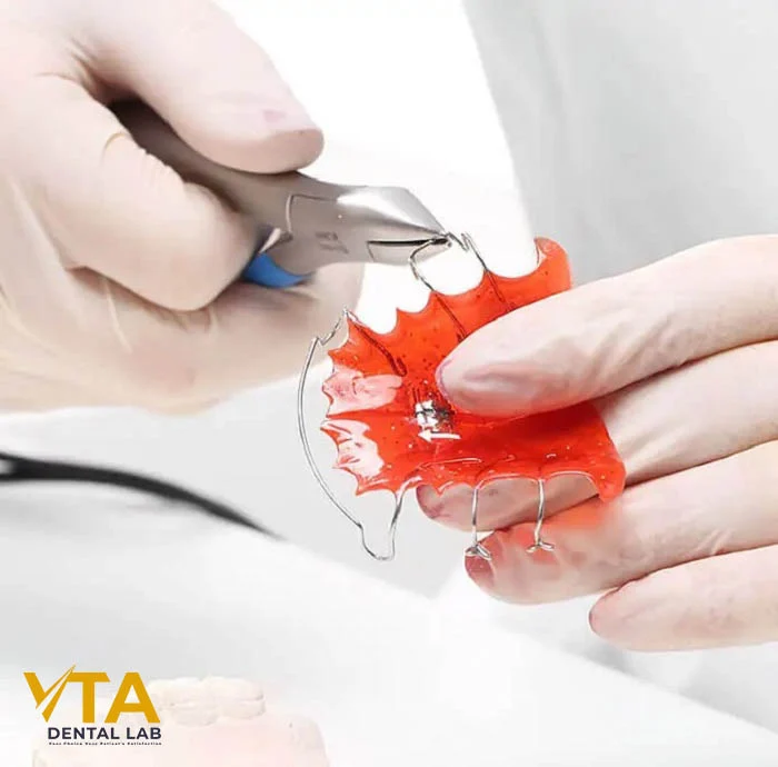 Laboratory technician adjusting the wire of a custom-made Hawley retainer